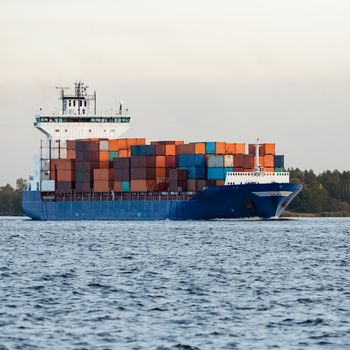 Blue container ship moving to Baltic sea. Riga, Latvia