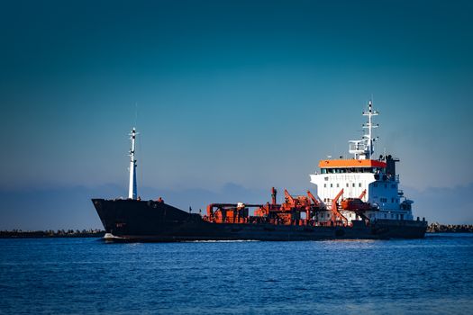 Black cargo oil tanker sailing in still water from Baltic sea