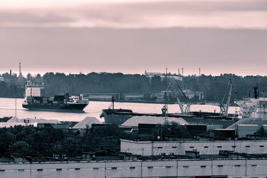 Red container ship entering port of Riga, Latvia