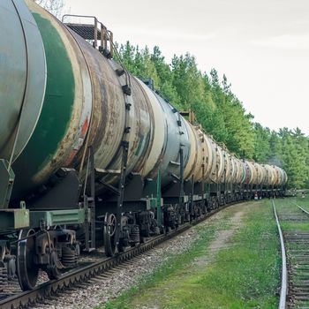 Tank wagons with oil. Freight train in forest