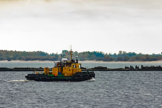 Small orange tug ship moving from the Baltic sea