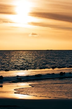 Vertical view of golden sunset at Baltic sea shore