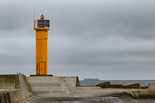 Breakwater dam with yellow lighthouse in Riga, Europe