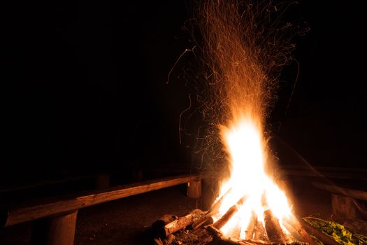 Campfire with flying sparks in the night