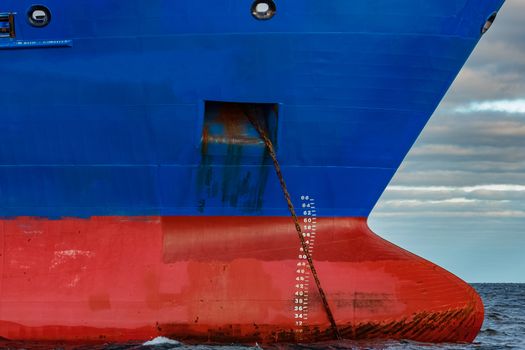 Blue cargo ship moored in still Baltic sea water