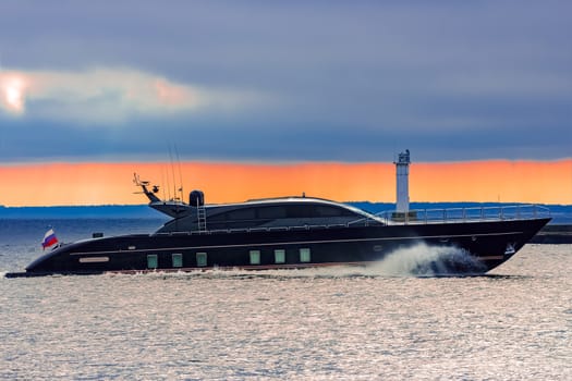 Black elite speed motor boat moving fast from Baltic sea