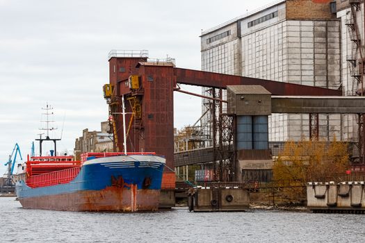 Blue cargo ship loading in the port of Riga, Europe