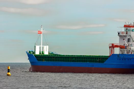 Blue cargo ship entering the Baltic sea. Riga, Europe