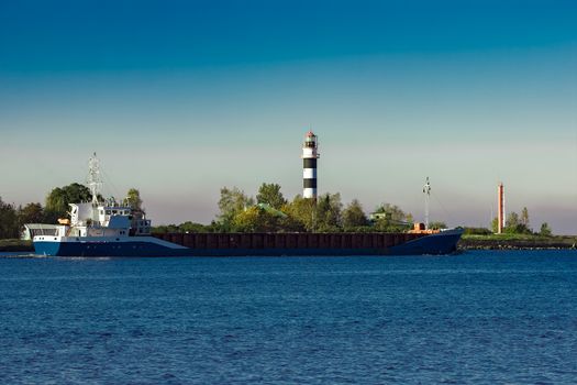 Blue cargo ship leaving Riga and entering Baltic sea