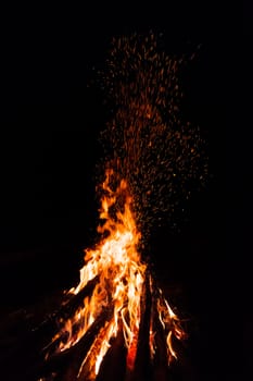 Campfire with flying sparks isolated on black background