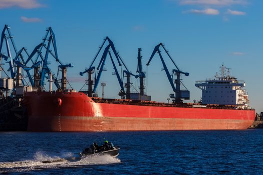 Red cargo ship loading in the port of Riga, Europe