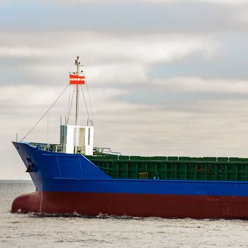 Blue cargo ship's bow leaving the port of Riga