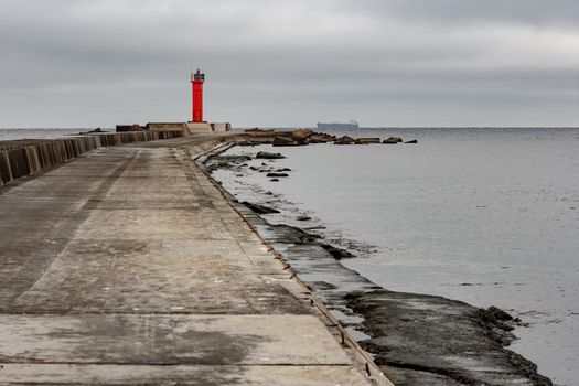 Breakwater dam with red lighthouse in Riga, Europe