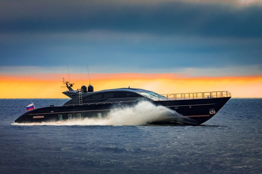 Black elite speed motor boat moving fast from Baltic sea