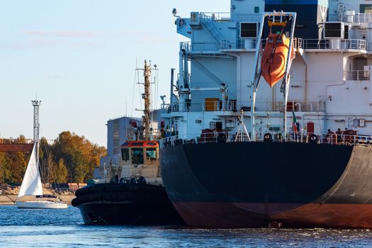 Black cargo ship entering the port of Riga, Europe