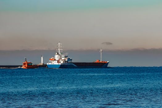 Blue cargo ship leaving Riga and entering Baltic sea