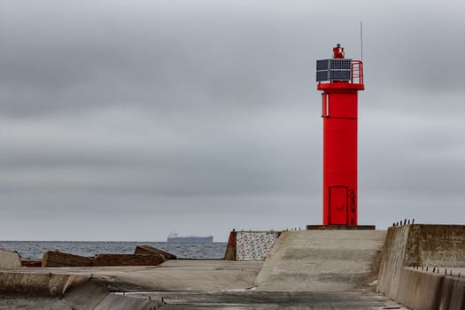 Breakwater dam with red lighthouse in Riga, Europe