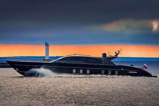 Black elite speed motor boat moving fast from Baltic sea