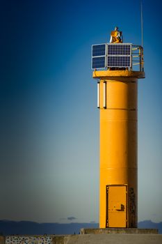 Yellow lighthouse on breakwater dam in Riga, Europe