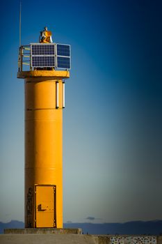 Yellow lighthouse on breakwater dam in Riga, Europe