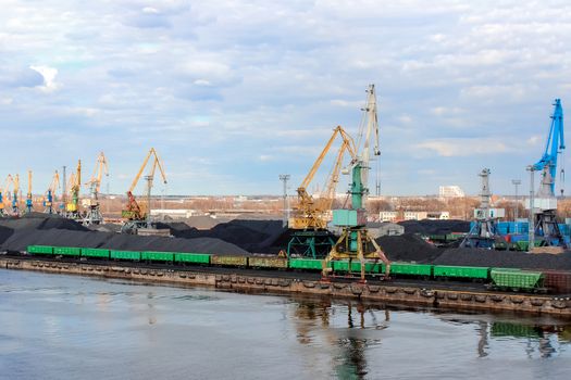 Baltic coal terminal with port cranes near the river. Riga cargo