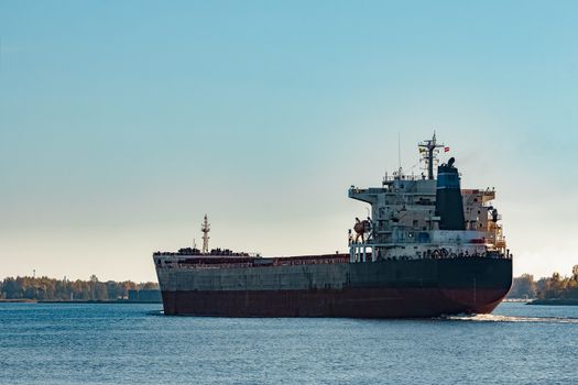 Black cargo ship entering Riga, Europe