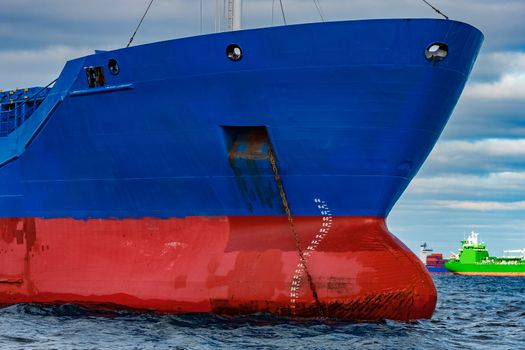 Blue cargo ship moored in still Baltic sea water