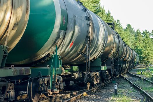 Tank wagons with oil. Freight train in forest