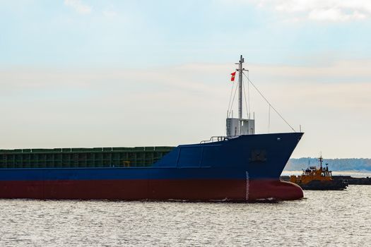 Blue cargo ship's bow leaving the port of Riga