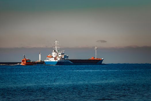 Blue cargo ship leaving Riga and entering Baltic sea