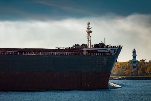 Black cargo ship's bow entering Riga, Europe