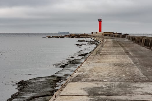 Breakwater dam with red lighthouse in Riga, Europe