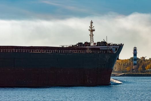 Black cargo ship's bow entering Riga, Europe