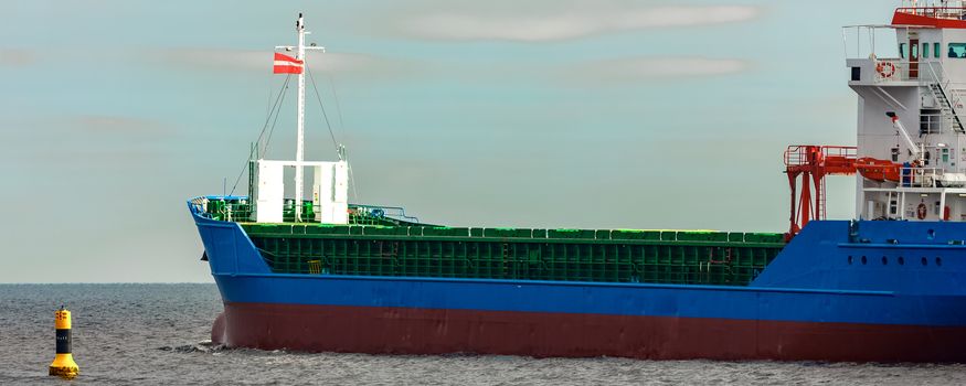 Blue cargo ship entering the Baltic sea. Riga, Europe