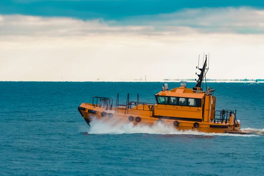 Orange pilot ship moving fast in Baltic sea. Europe