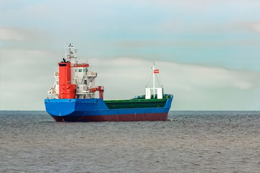 Blue cargo ship entering the Baltic sea. Riga, Europe