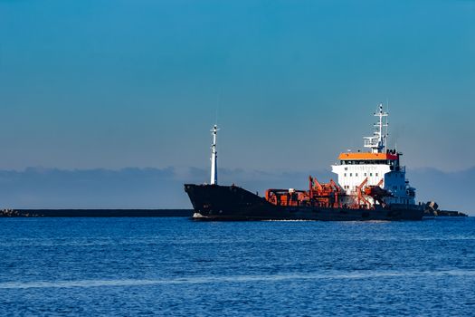 Black cargo oil tanker sailing in still water from Baltic sea