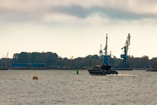 Black elite speed motor boat entering Riga