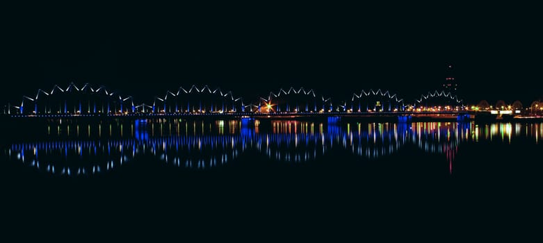 Illuminated railroad bridge in night city, Latvia. Riga bridge