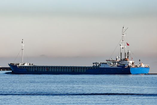 Blue cargo ship leaving Riga and entering Baltic sea