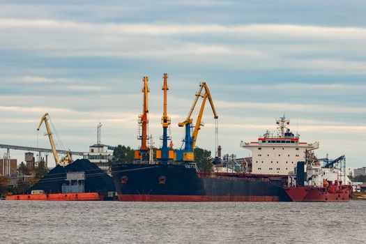 Black cargo ship loading in the port of Riga, Europe