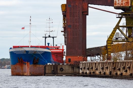 Blue cargo ship loading in the port of Riga, Europe