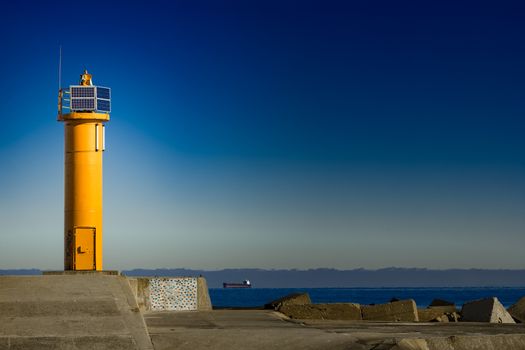 Yellow lighthouse on breakwater dam in Riga, Europe