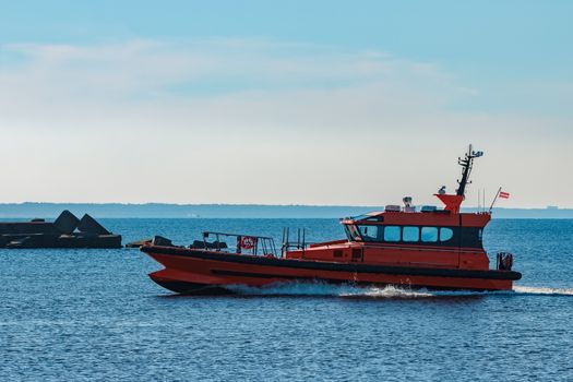 Orange pilot ship moving fast from Baltic sea