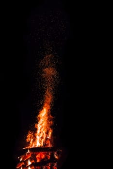 Campfire with flying sparks isolated on black background