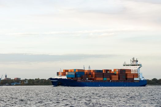 Blue container ship moving to Baltic sea. Riga, Latvia