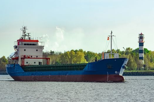 Blue cargo ship leaving the port of Riga at sunny day
