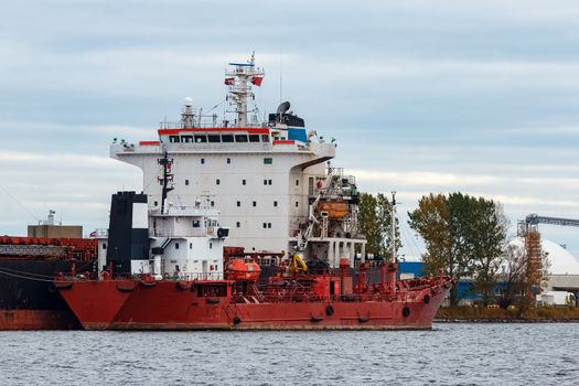 Red cargo ship loading in the port of Riga, Europe