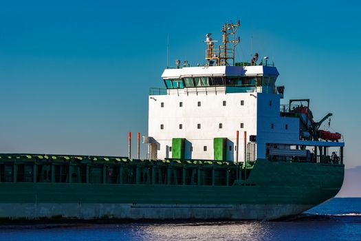 Green cargo ship's cabin in still Baltic sea water, Riga