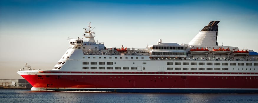 Red cruise liner. Passenger ferry ship sailing in still water